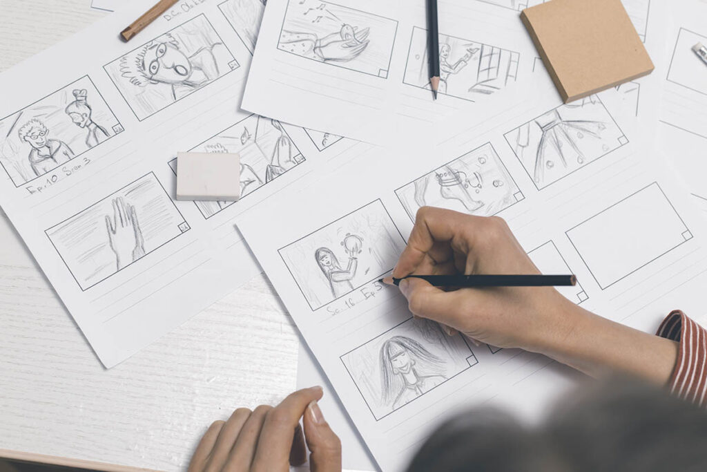 Person sketching out a storyboard with pencil and paper