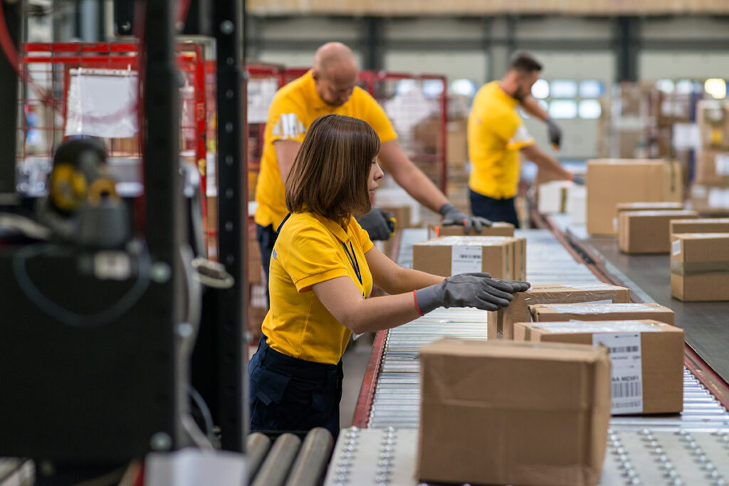 Warehouse employees packing boxes on a conveyor belt