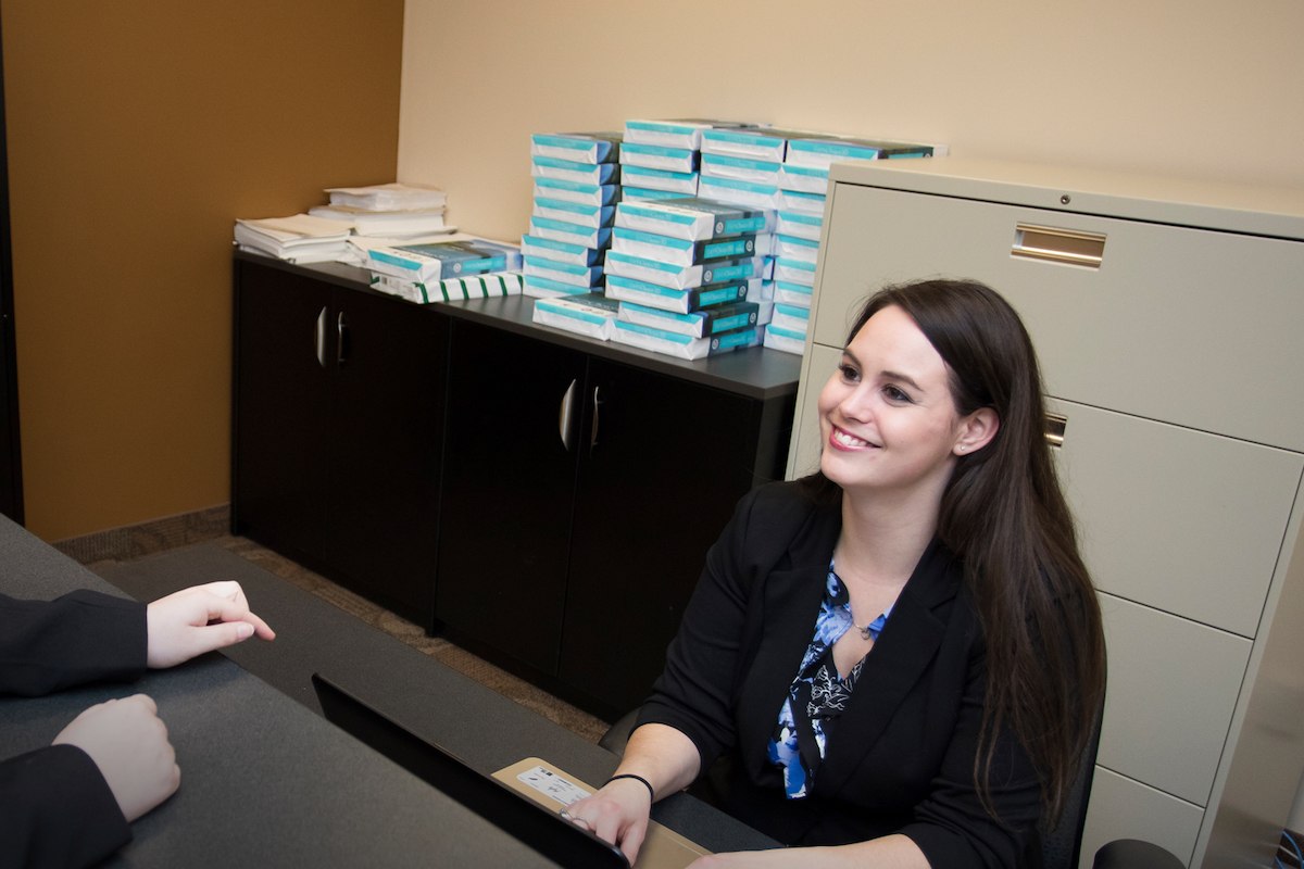 Administrative Assistant sitting behind a desk