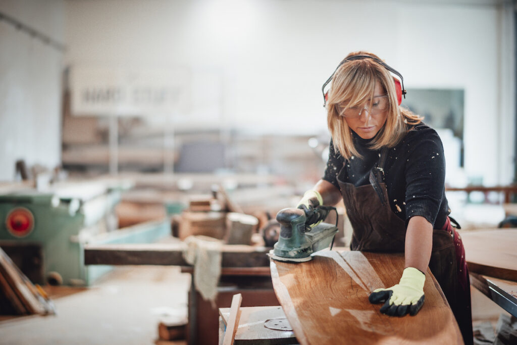 Woman sanding piece of wood