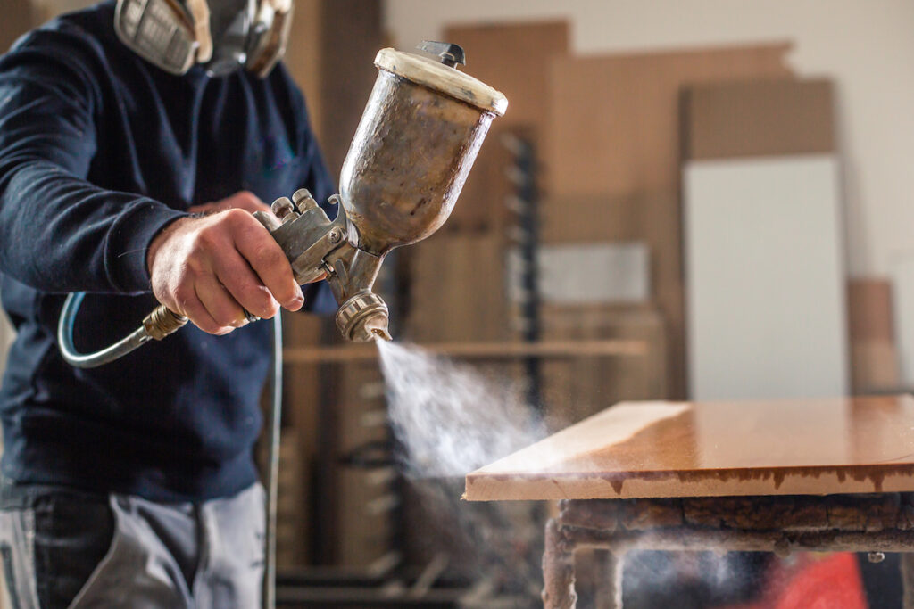 Man staining a piece of wood