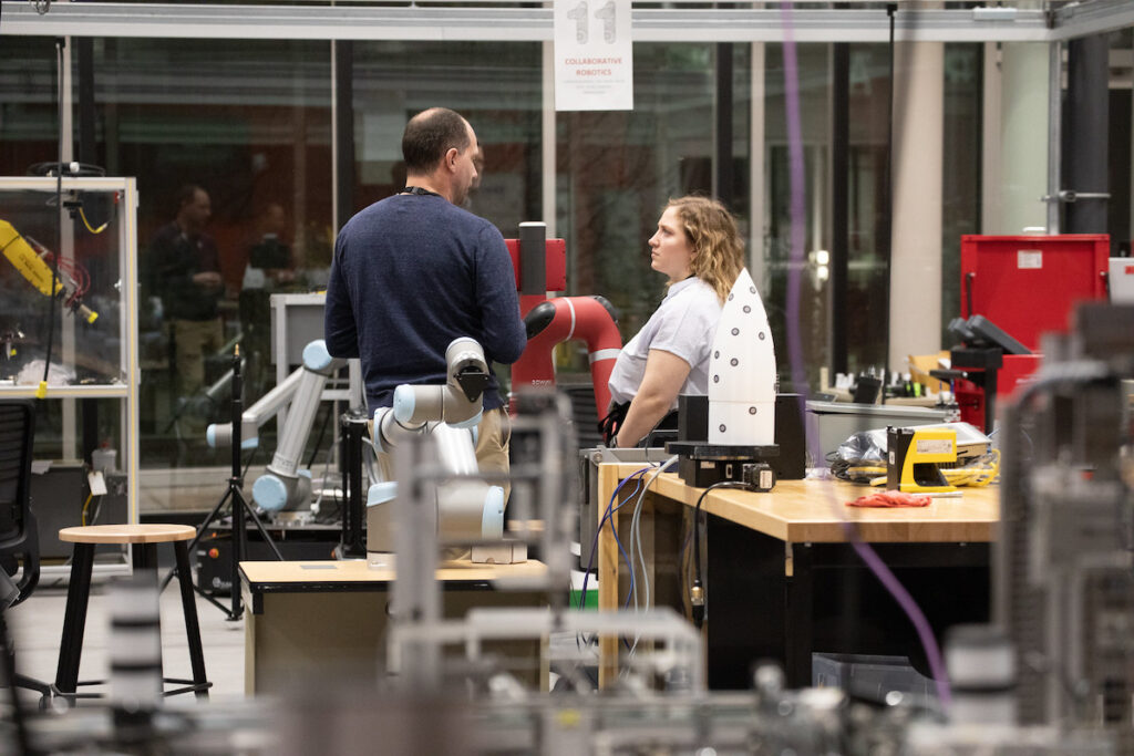Two people talking in a robotics lab