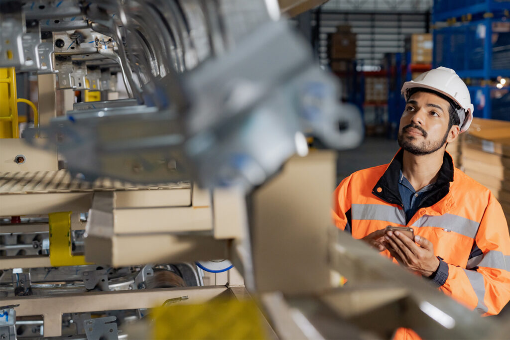 Man standing beside a manufacturing line