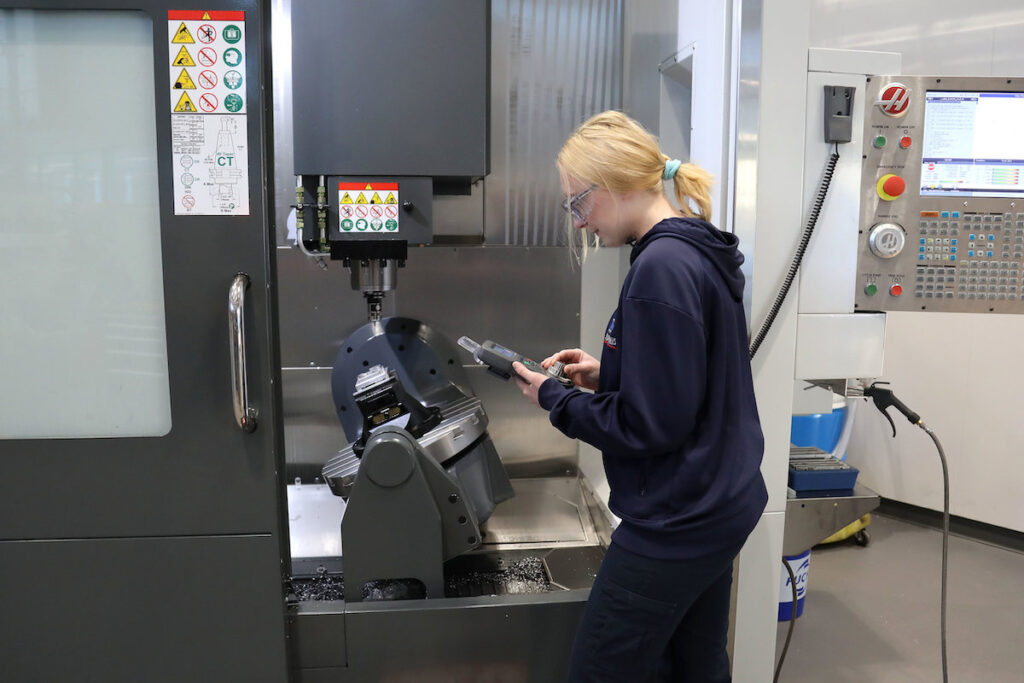 Student working with advanced manufacturing tool