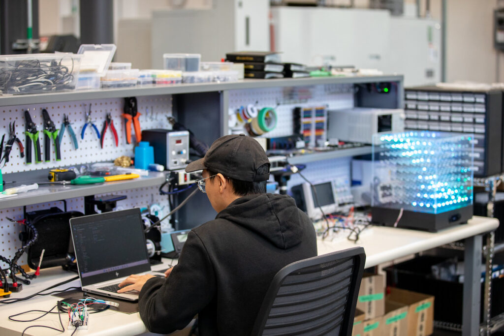 Student working on laptop in workshop