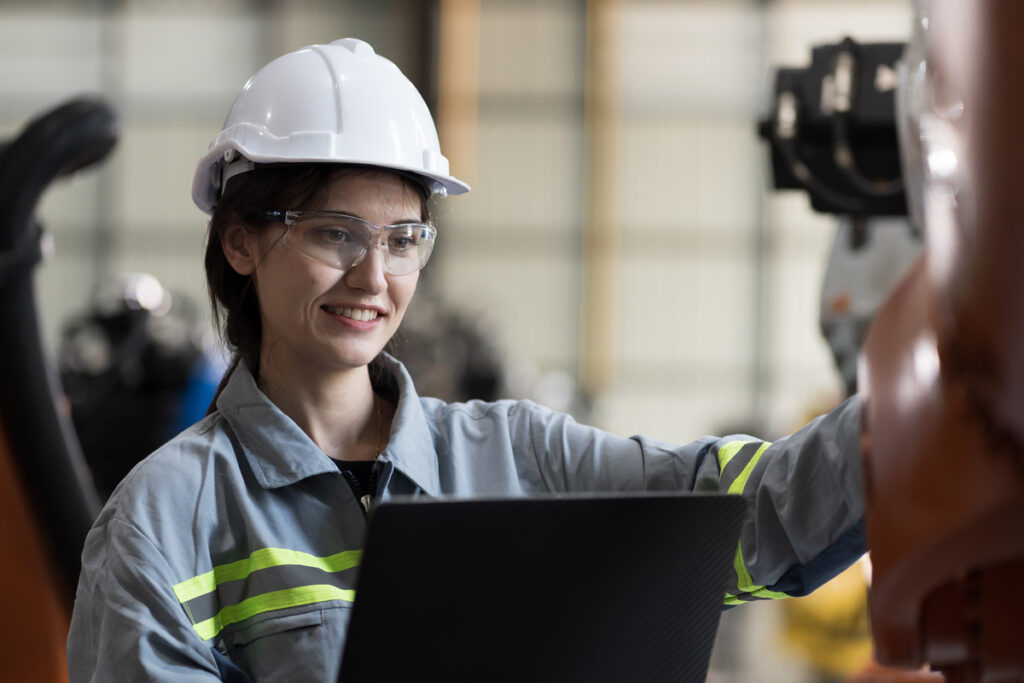 Woman in hard hat working on laptop