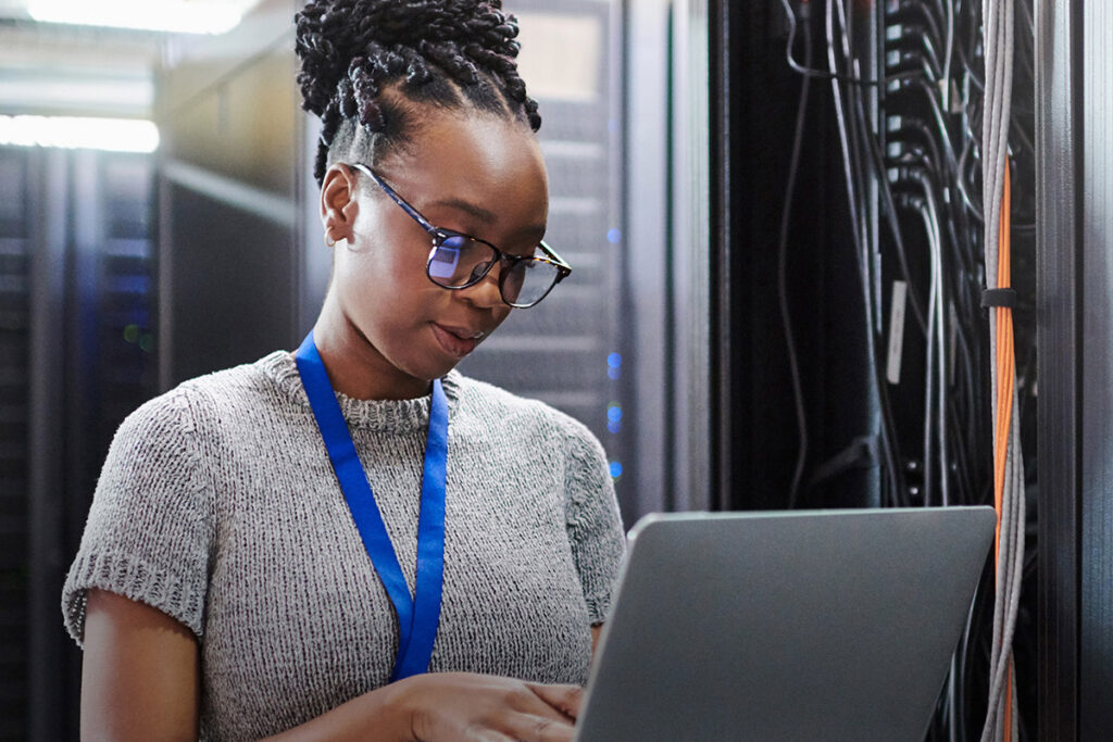 Woman in a data centre using a laptop