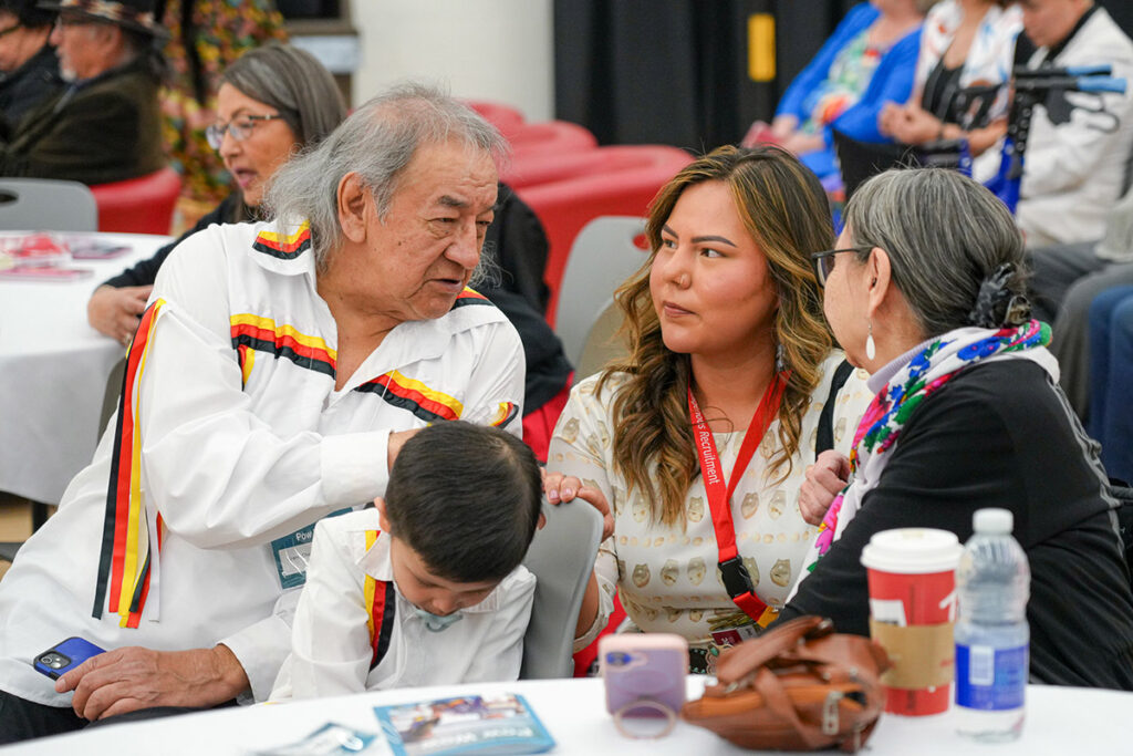Group of people talking at a graduation pow wow