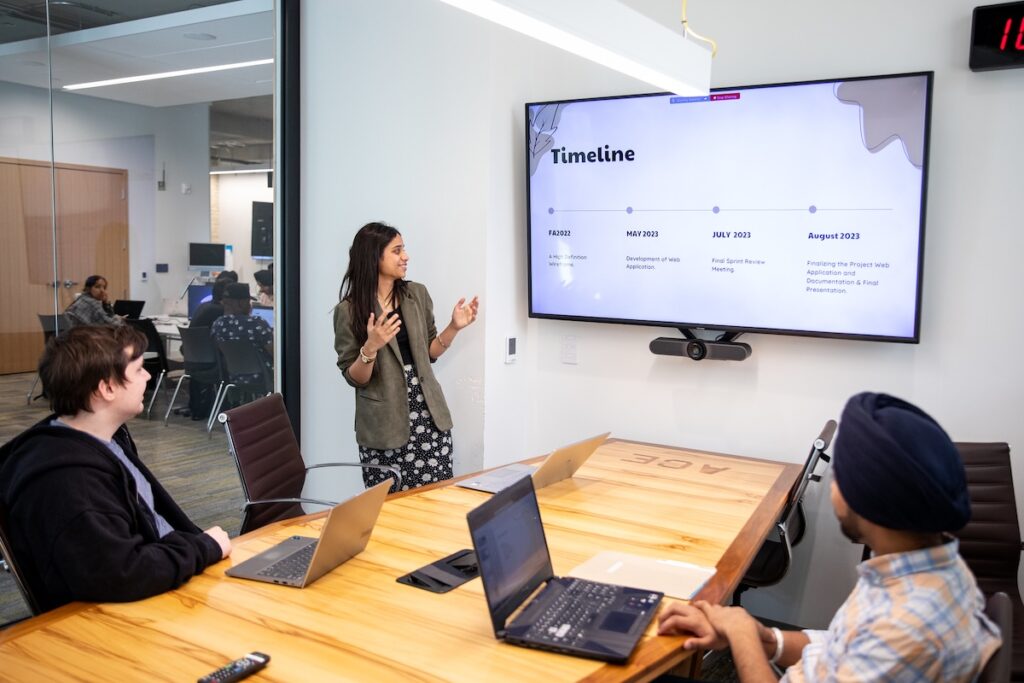 student presenting about a project timeline in a boardroom