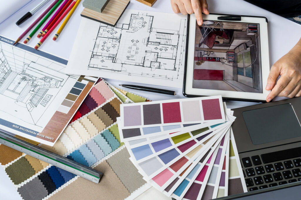 Top-down view of an interior designer working with colour swatches, shop drawings and material samples