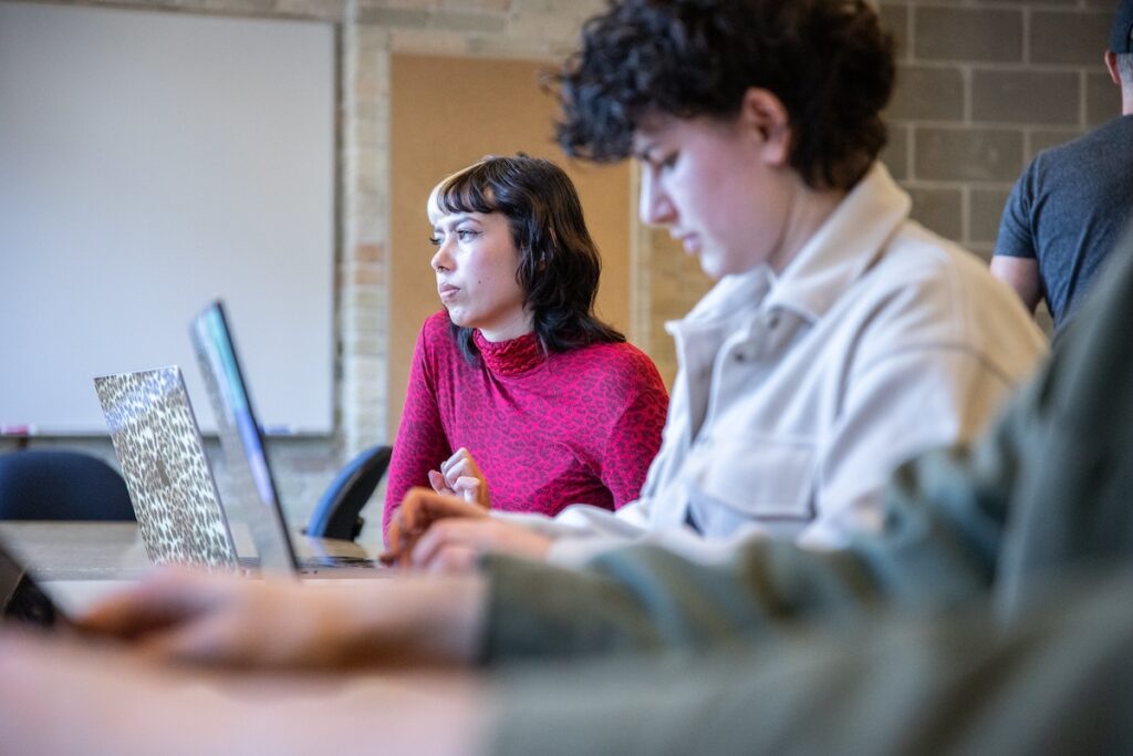 Student editing footage on a computer, working with professional video editing software in a media lab.