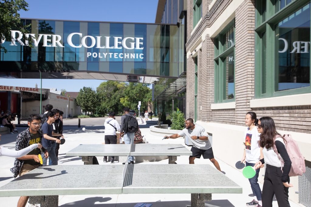 a diverse group of students playing ping-pong outside RRC Polytech’s Exchange District Campus