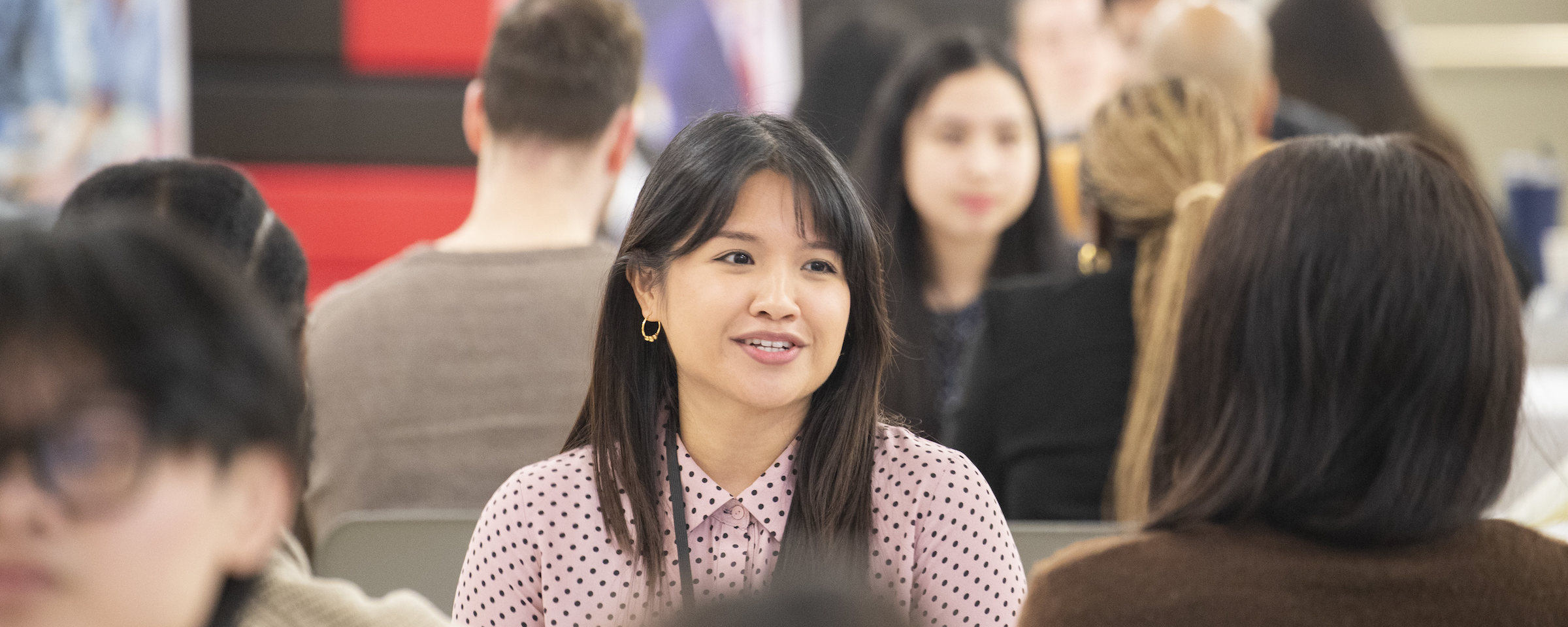 Student smiling while engaged in conversation at a networking or career event