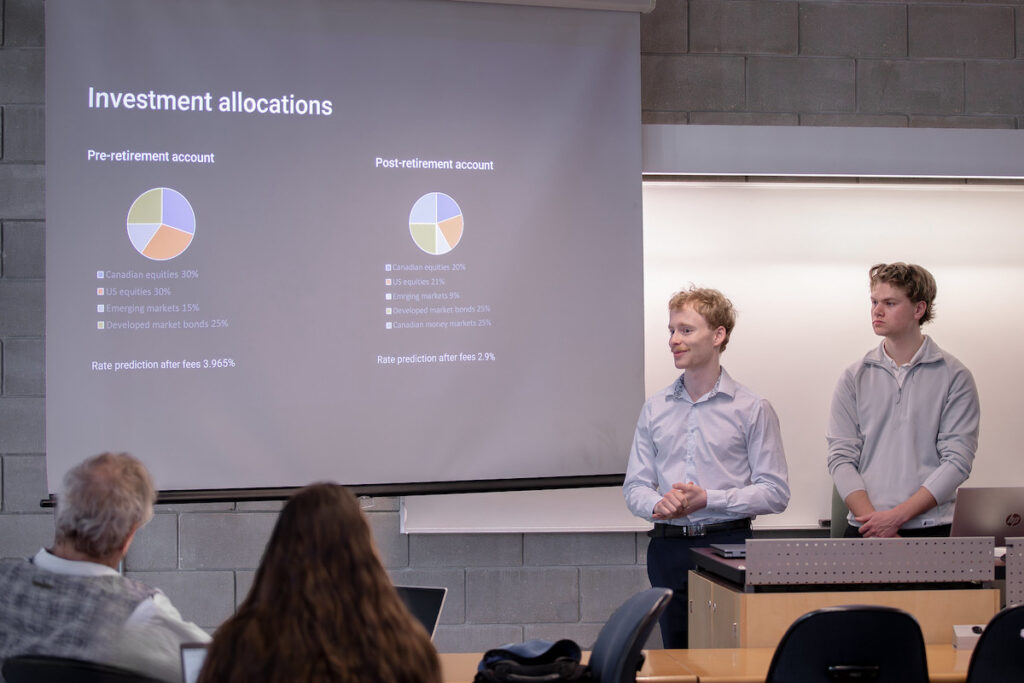Two students delivering a financial presentation with pie charts showing investment portfolio allocations to an audience
