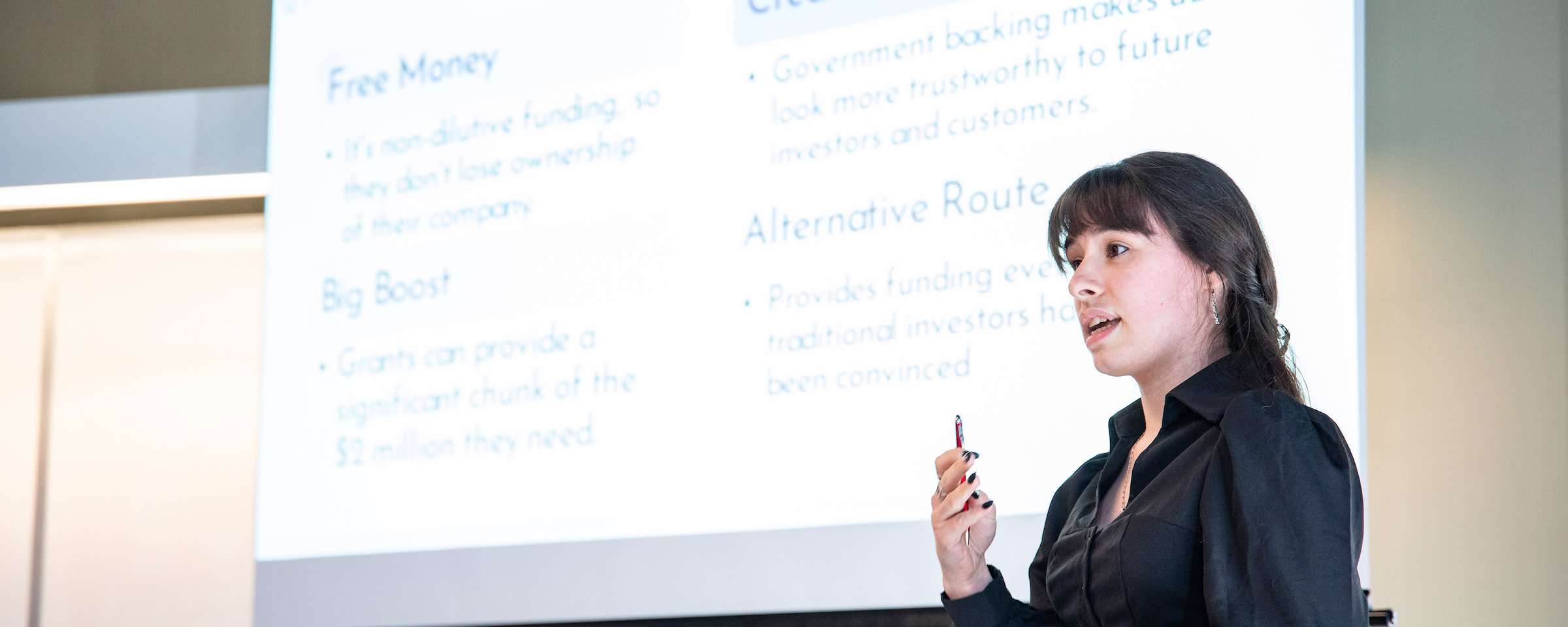 Business instructor delivering a presentation with projected slides