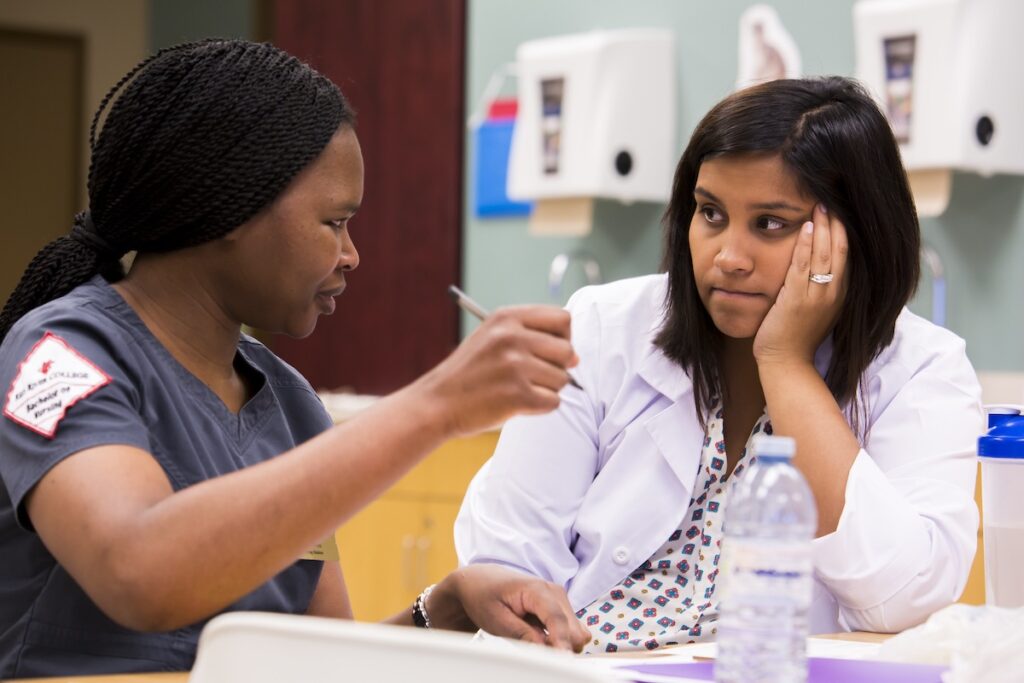 Nursing student presents a patient care scenario during a clinical discussion with an instructor.