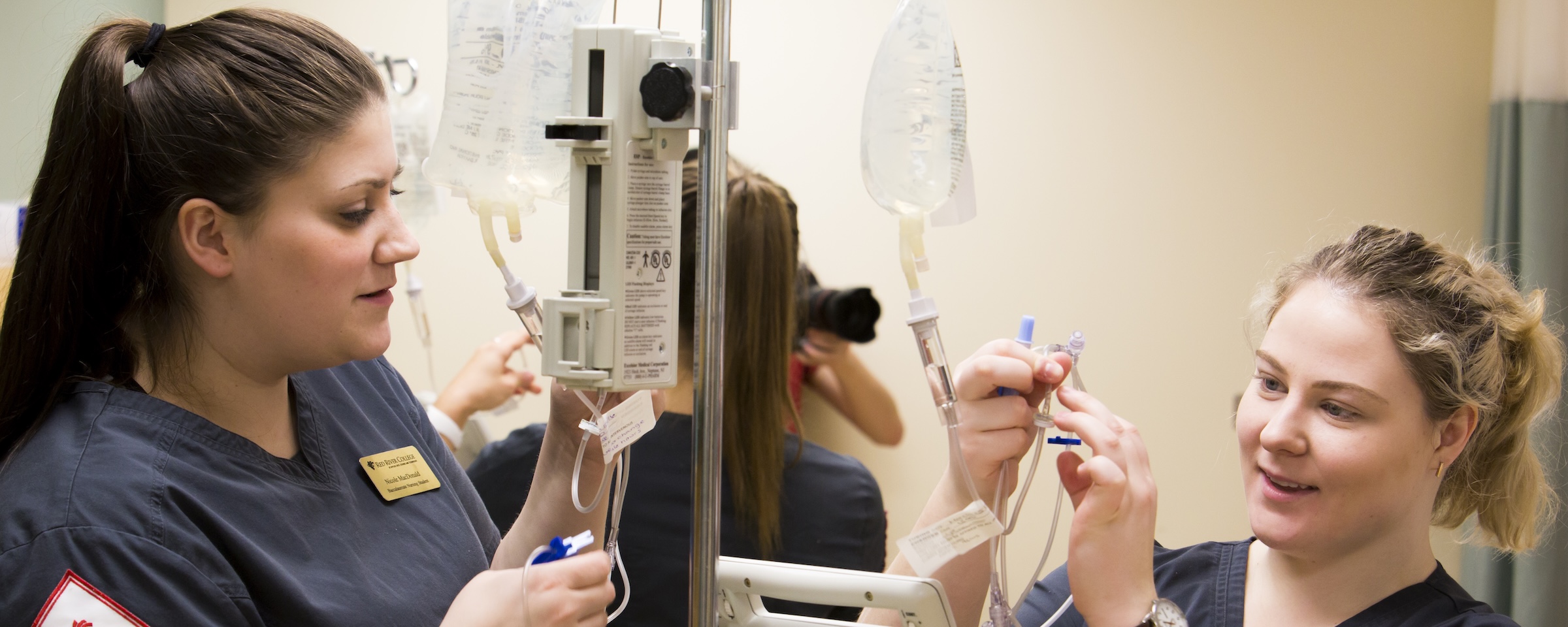 Nursing students practice intravenous therapy skills in a clinical simulation lab.