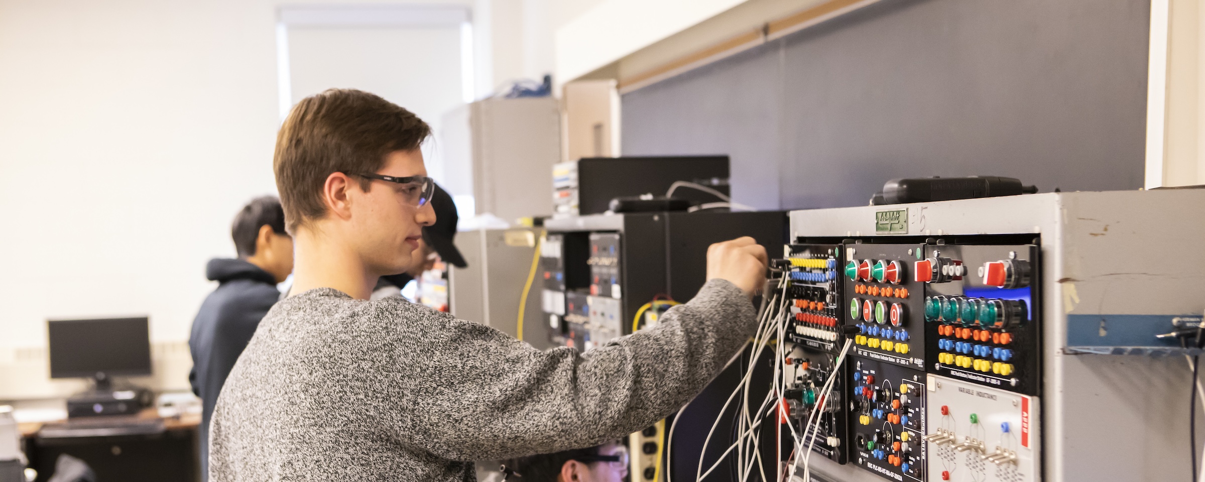 Student configures and tests electrical control systems in an engineering technology lab.