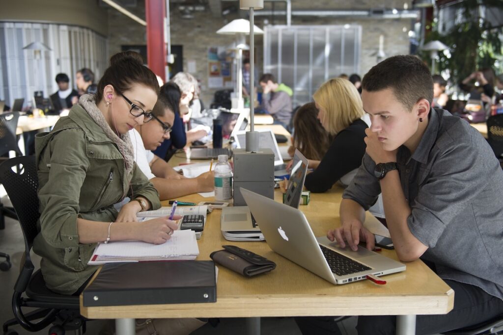 Students collaborate on coursework and computer-based problem solving in a campus study space.