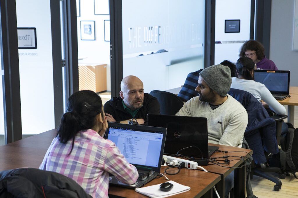 Students collaborate on software development and technology projects in a computer lab.