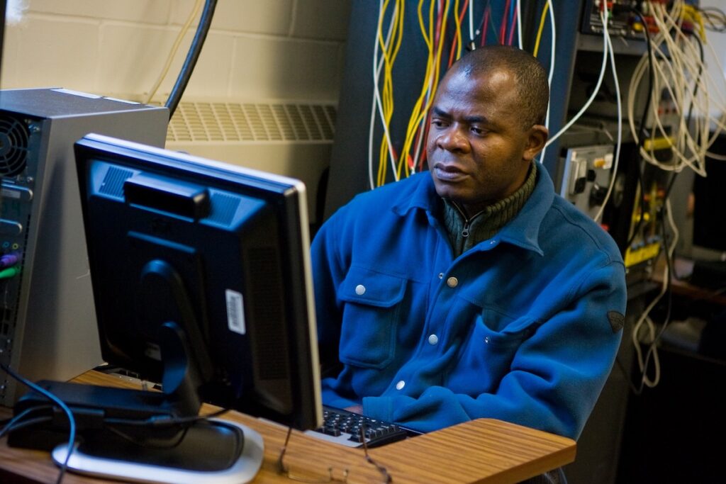 Student monitors computer systems and network equipment in a technology laboratory.