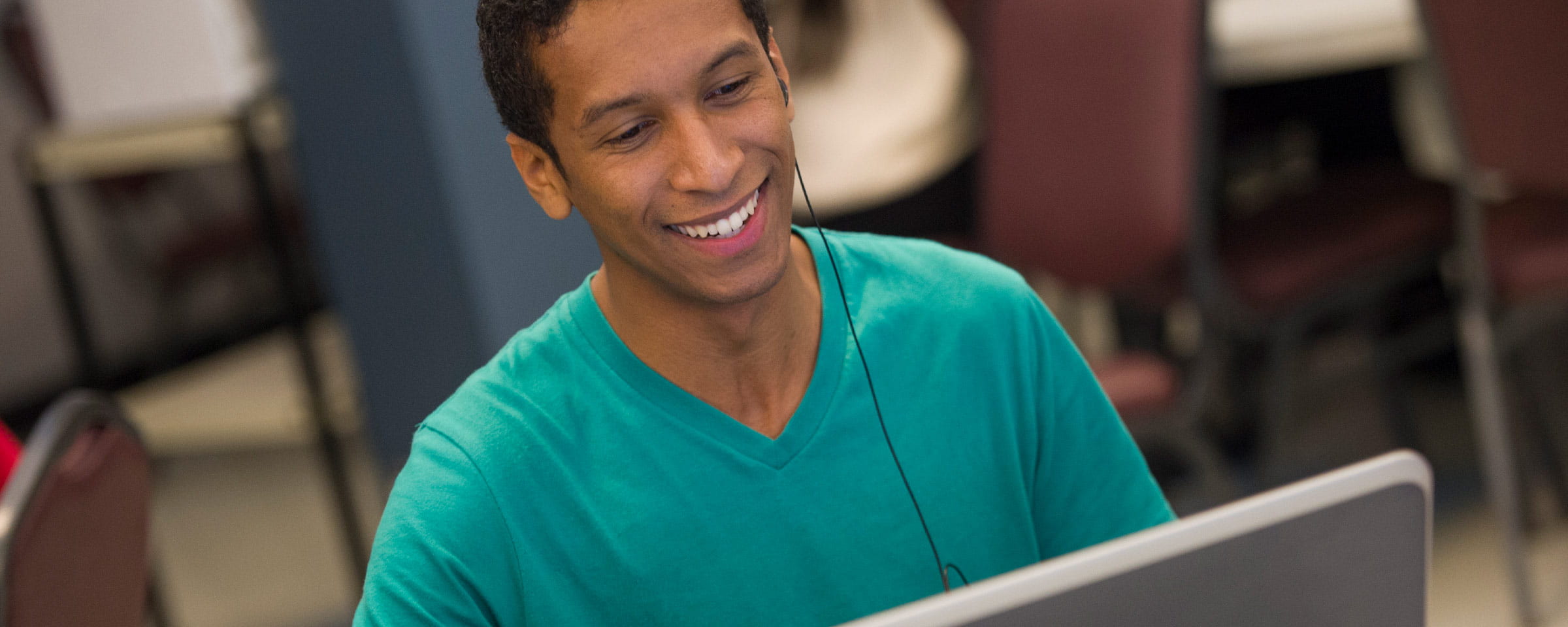 Smiling man looking at laptop screen