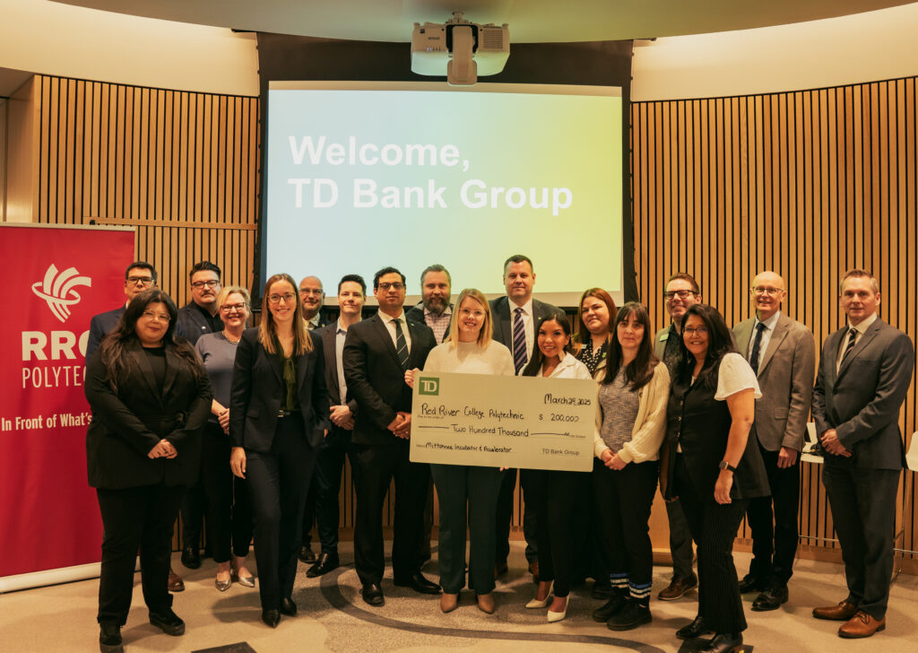 A group of people smile at the camera, while holding a large cheque.