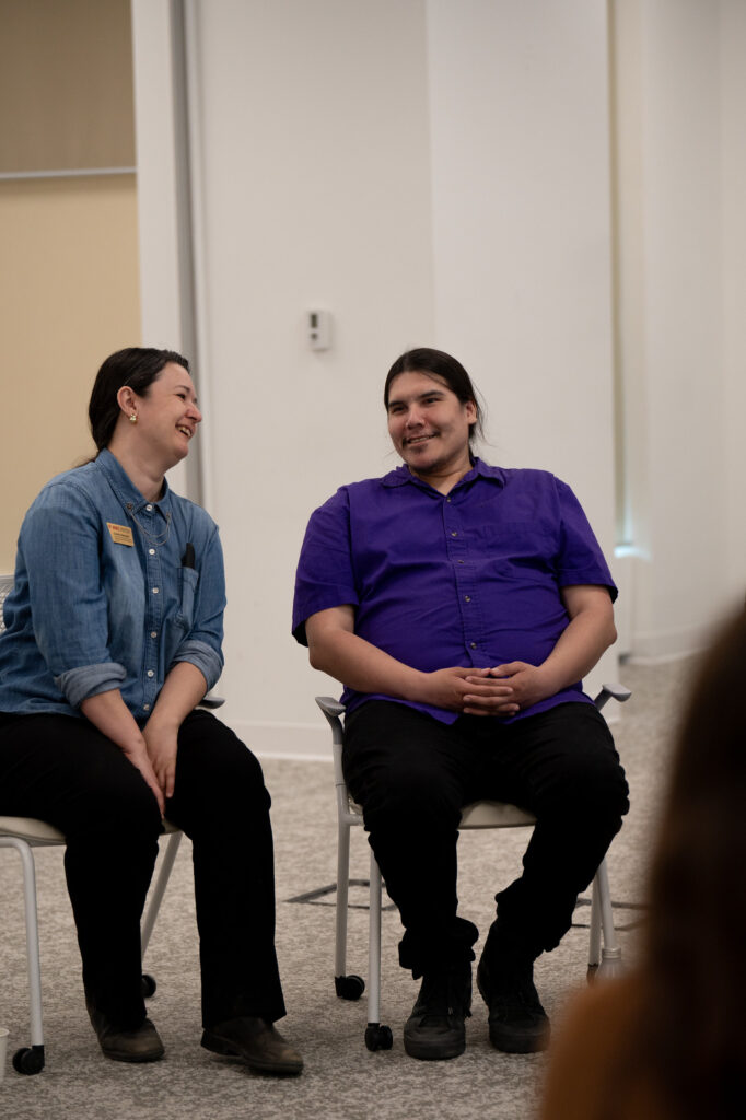Two people sit together and smile.
