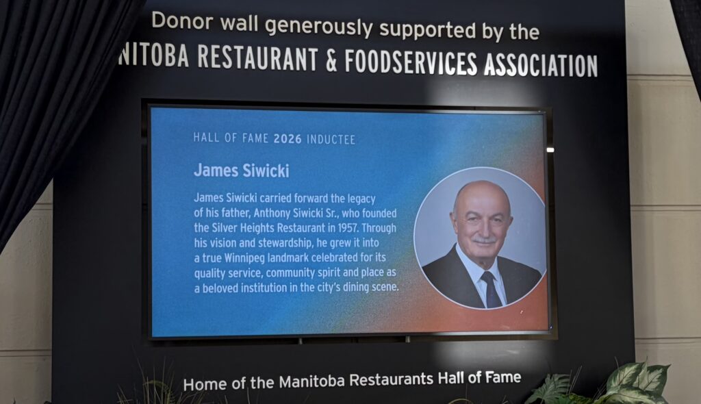 Donor wall generously supported by the Manitoba Restaurant & Foodservices Association. Image features a photo to James Siwicki, one of the 2026 inductees. He is looking at the camera and is wearing a suit.