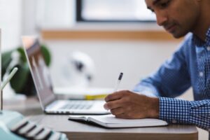 student takes notes from laptop