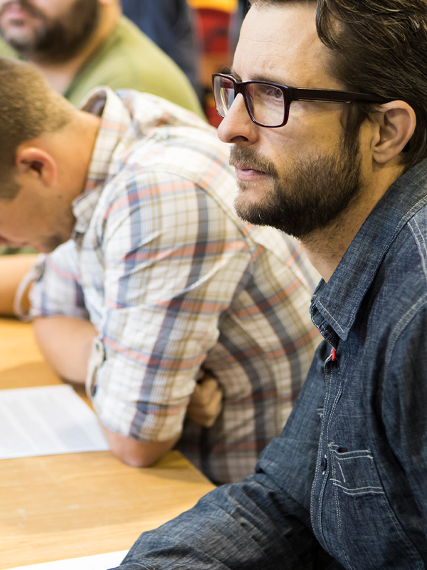 man with glasses listening intently