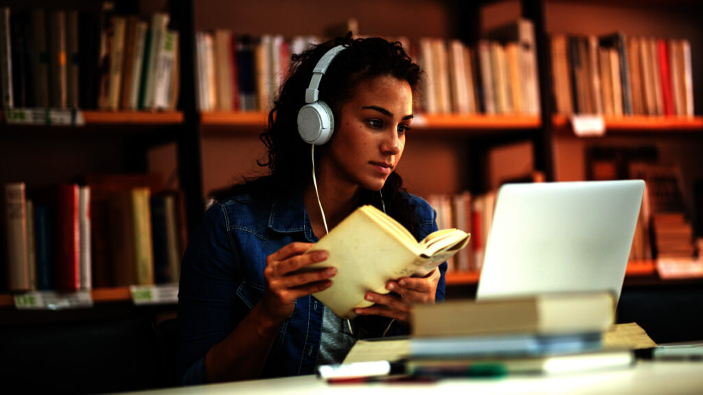 Young female student study in the school library. She using laptop and learning online.