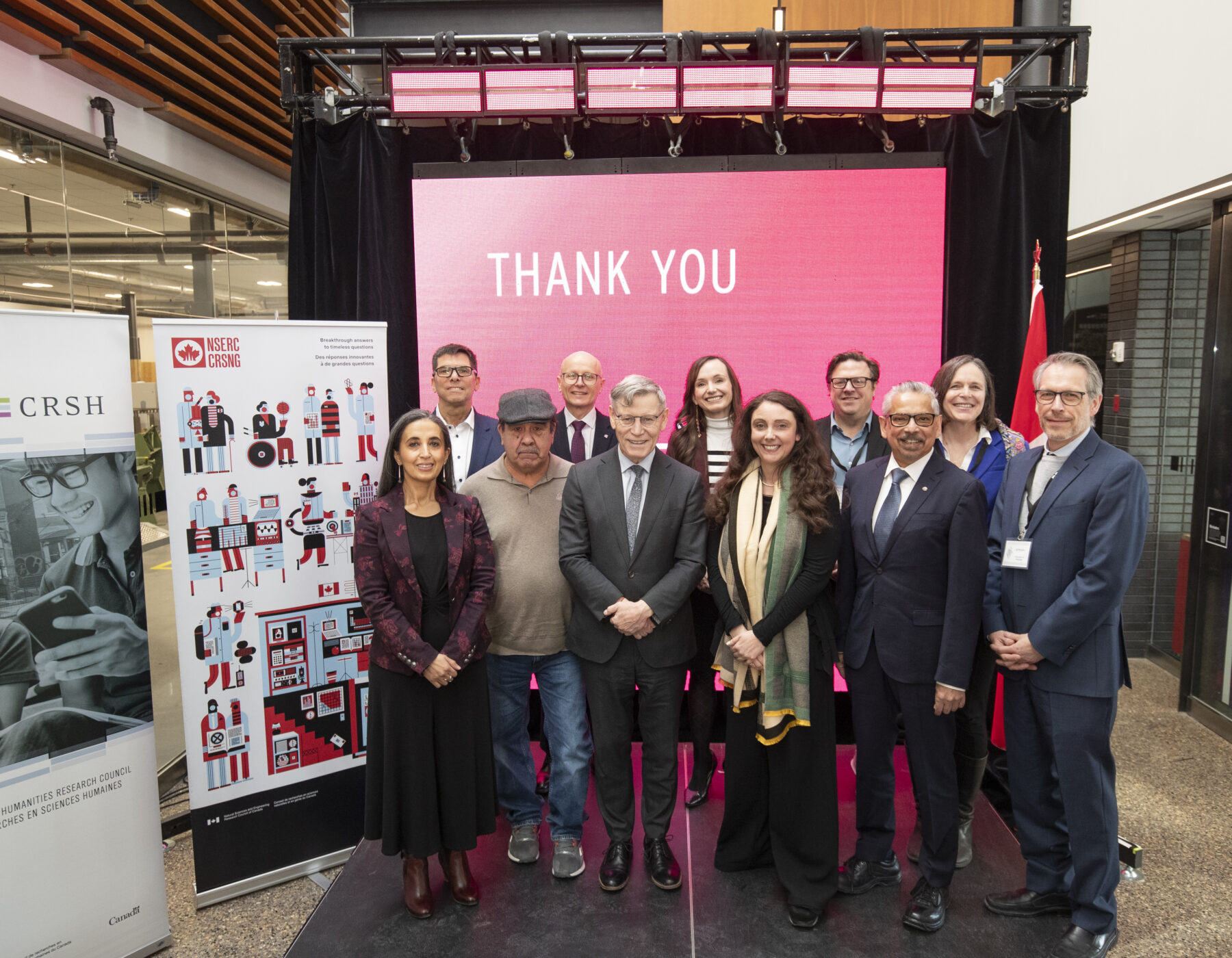 a group photo on the stage at the announcement of network leads from RRC Polytech, Dalhousie University, University of Guelph and Simon Fraser University, along with Elder Paul, Fred Meier, Minister Duguid, Minister Cable and NSERC's VP of Vice-President, Research and Technology Partnerships Directorate