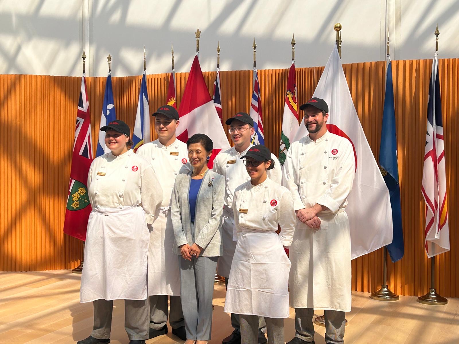 Five chefs posing for a photo with the Imperial Princess of Japan