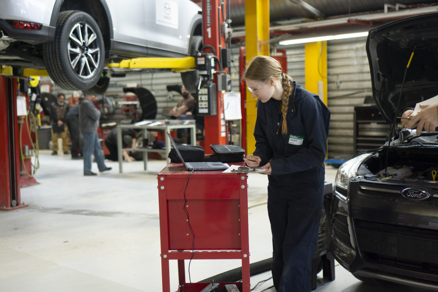 a mechanic hoisting a car
