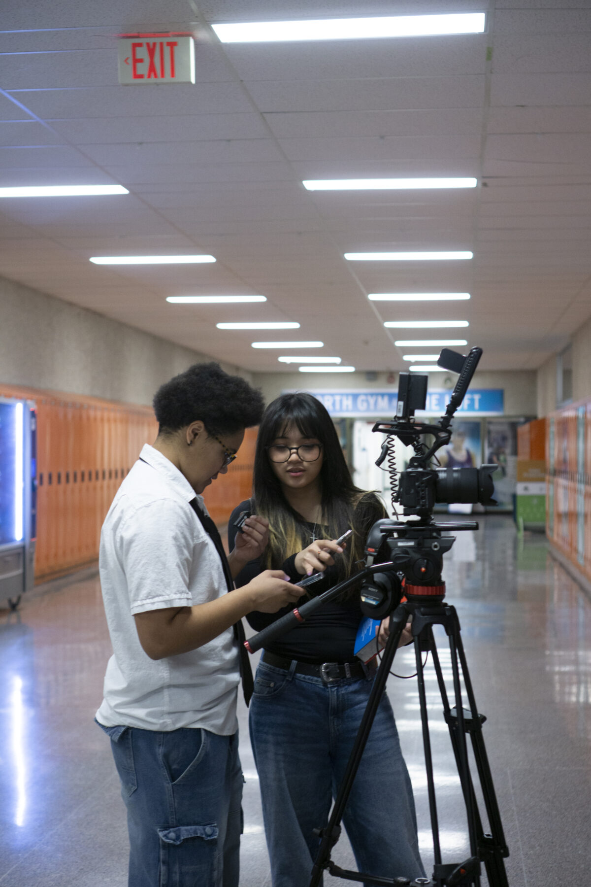 2 students adjust a video camera