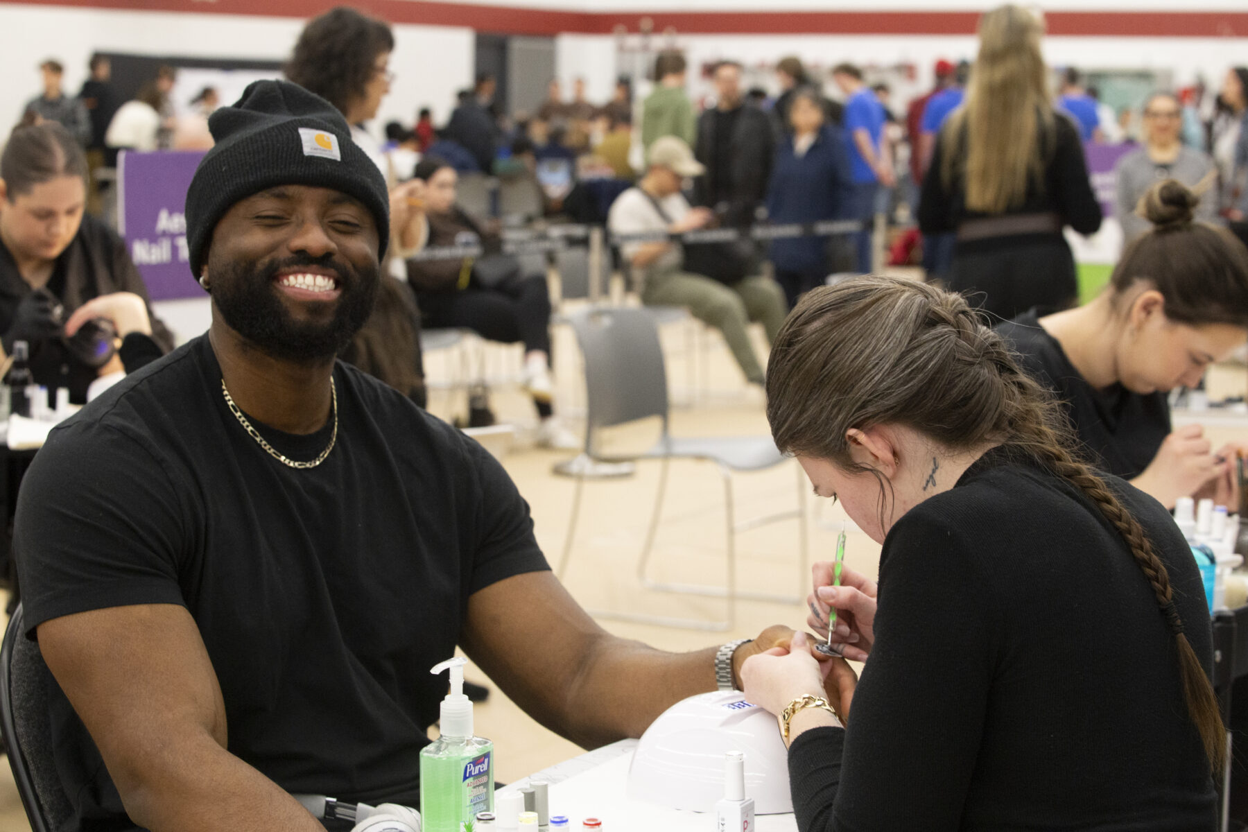 a person smiles while their fingernails are painted