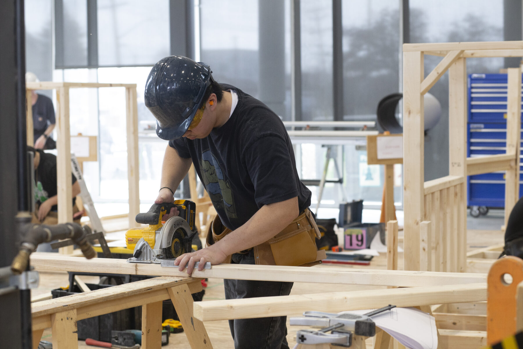 a construction worker sawing a piece of wood