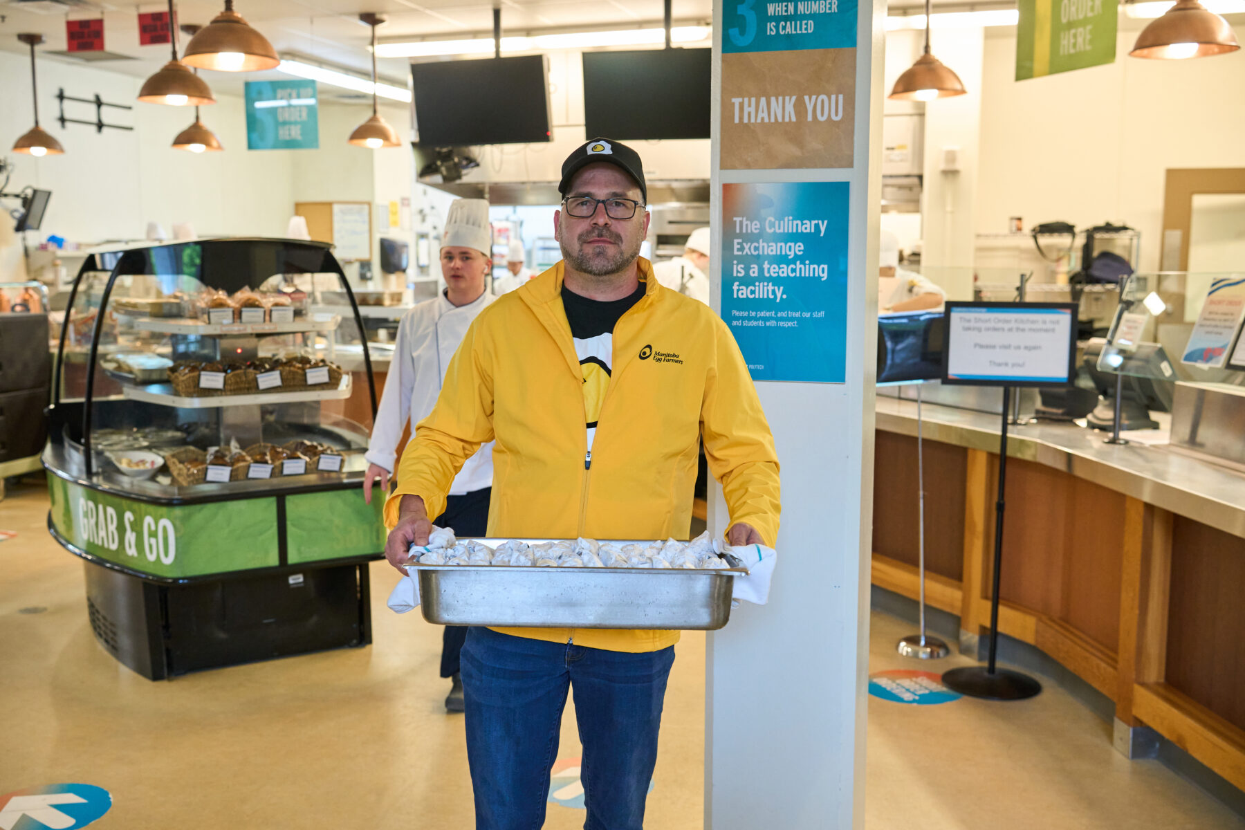 person holding a tray of egg sandwiches