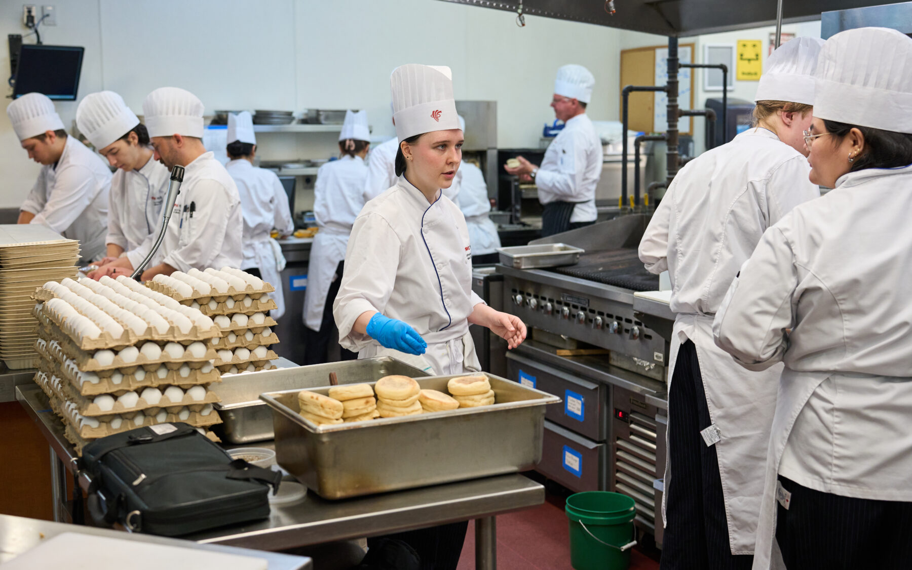 student chefs preparing egg sandwiches in a busy kitchen