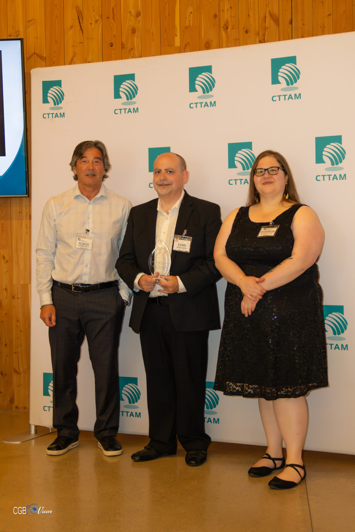 Three people stand and smile at the camera.