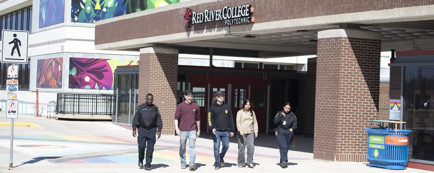 Five people walking outside the bus loop at the Notre Dame Campus