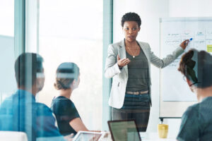 Woman in boardroom writing on flip chart