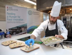 Culinary instructor plating food, Prairie Research Kitchen