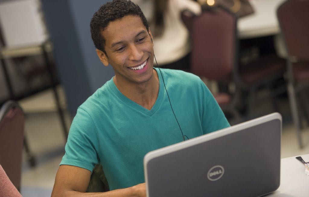 Smiling man looking at laptop screen