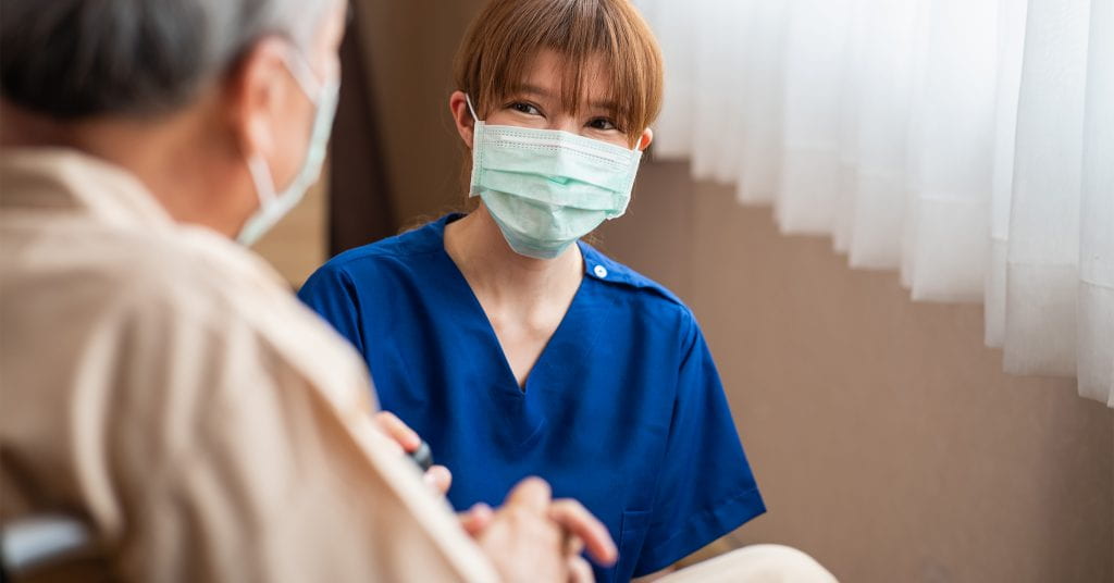 Female health-care aide with patient