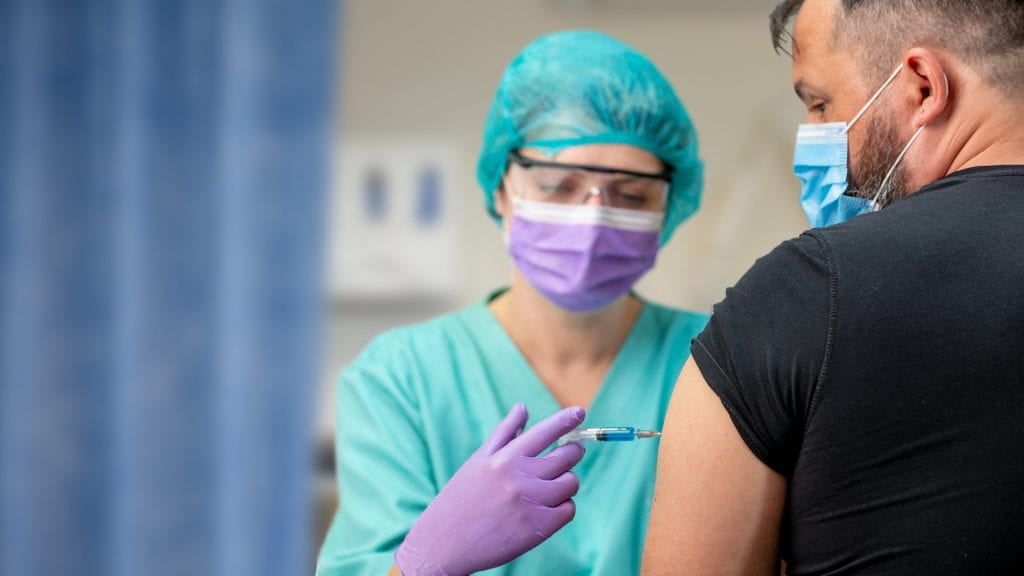 Heath-care worker administering COVID-19 vaccine