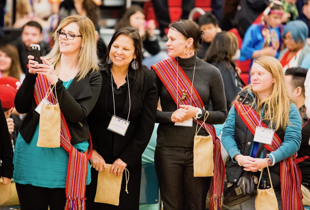 Women at graduation pow wow wearing Métis sashes