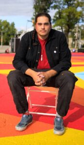 Local artist Peatr Thomas, seated near one of his outdoor murals