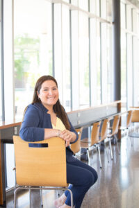 Disability and Community Support grad Laura Bustamante, seated near window